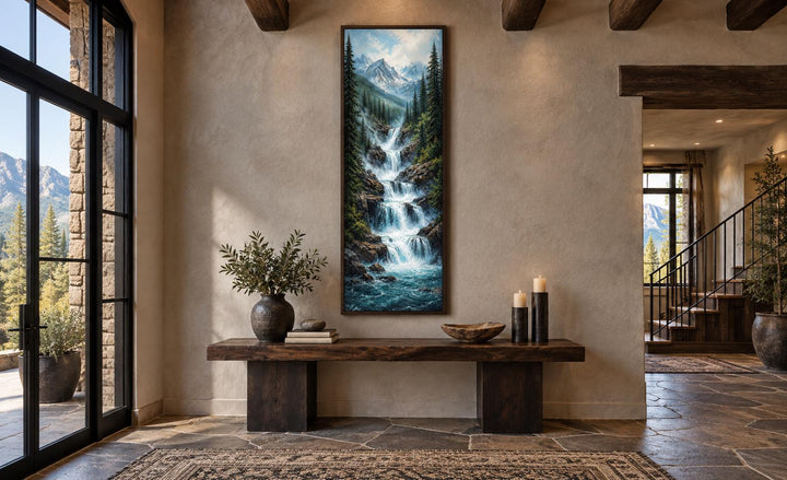 Vertical canvas art of a cascading waterfall through a pine forest with snow-capped mountain peaks.