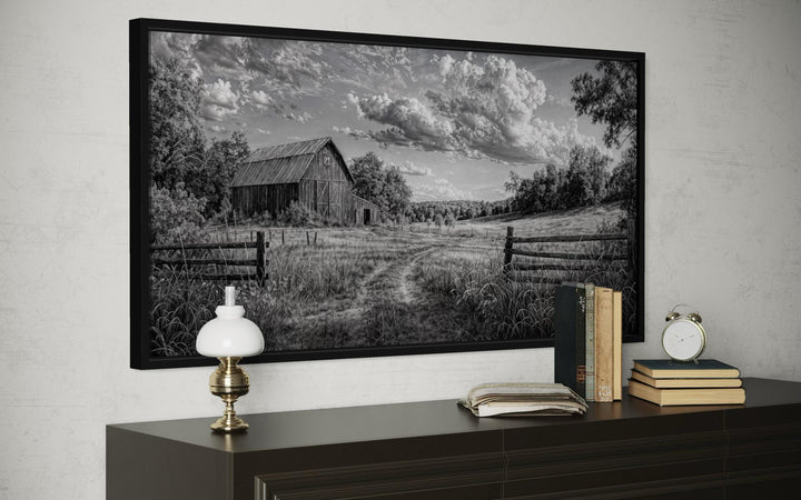 Black and white barn landscape canvas wall art in a black frame above a dark wood dresser.