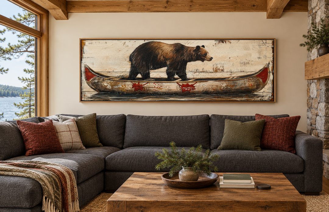 Bear in canoe long horizontal framed canvas wall art hanging above a sectional sofa in a cabin.