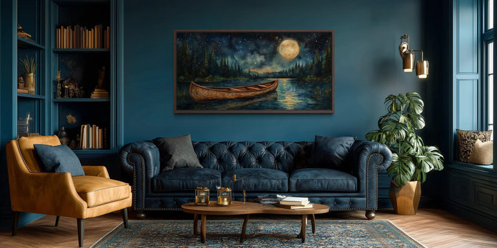 Canoe on moonlit lake and forest night scene canvas wall art displayed in a dark blue living room.