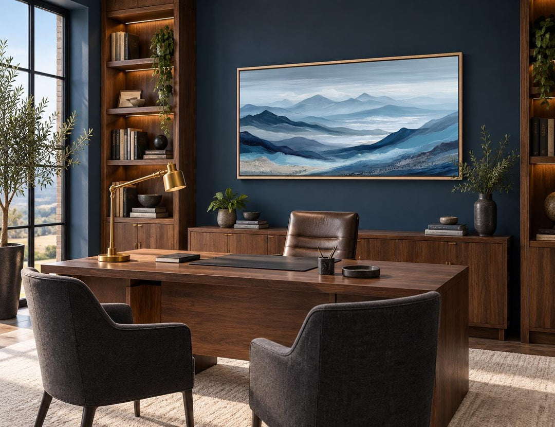 Blue mountain landscape canvas wall art with misty peaks in a horizontal frame above a wooden desk.