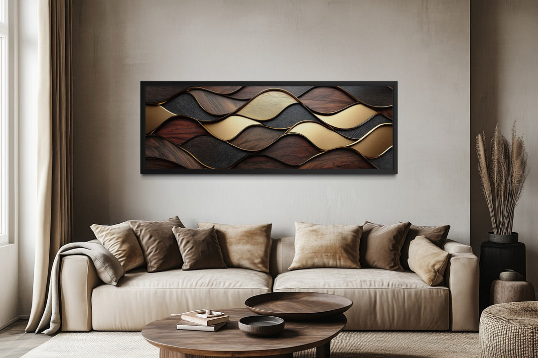 a modern living room with a large, beige sofa adorned with throw pillows. Above the sofa, there is a striking abstract artwork composed of various shades of brown and gold, creating a visually appealing focal point in the room.