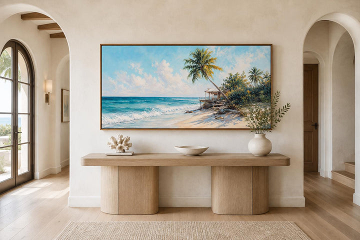 Tropical beach wall art with palm trees and turquoise waves above a wooden console table.