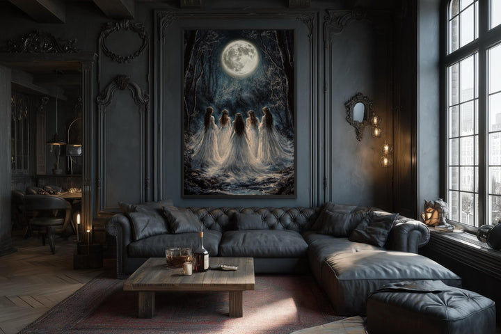 Vertical canvas print of gothic witches in a moonlit forest hanging in a dark, moody living room.