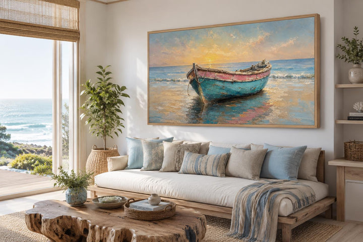 Weathered teal and pink rowboat painting on a coastal living room wall at golden sunset.