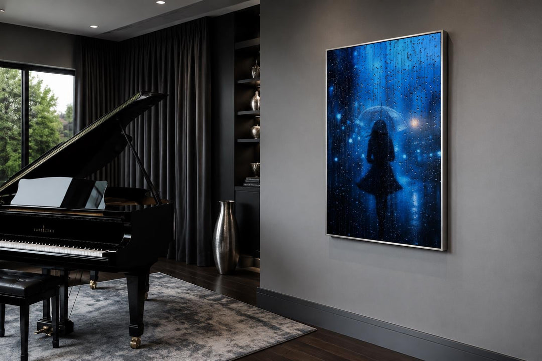 Vertical canvas art of a woman's silhouette with an umbrella in blue rain, hung in a modern room.