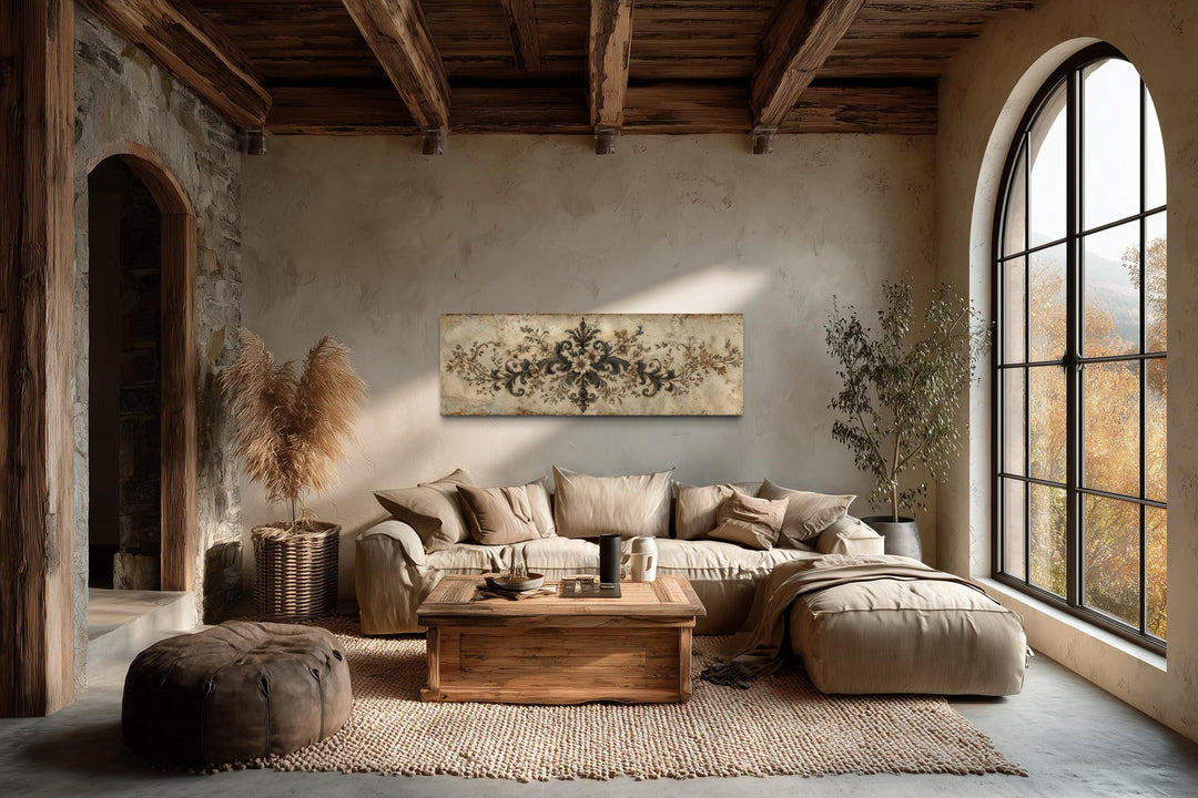 Antique neutral long narrow damask canvas wall art hangs above a sofa in a rustic living room.