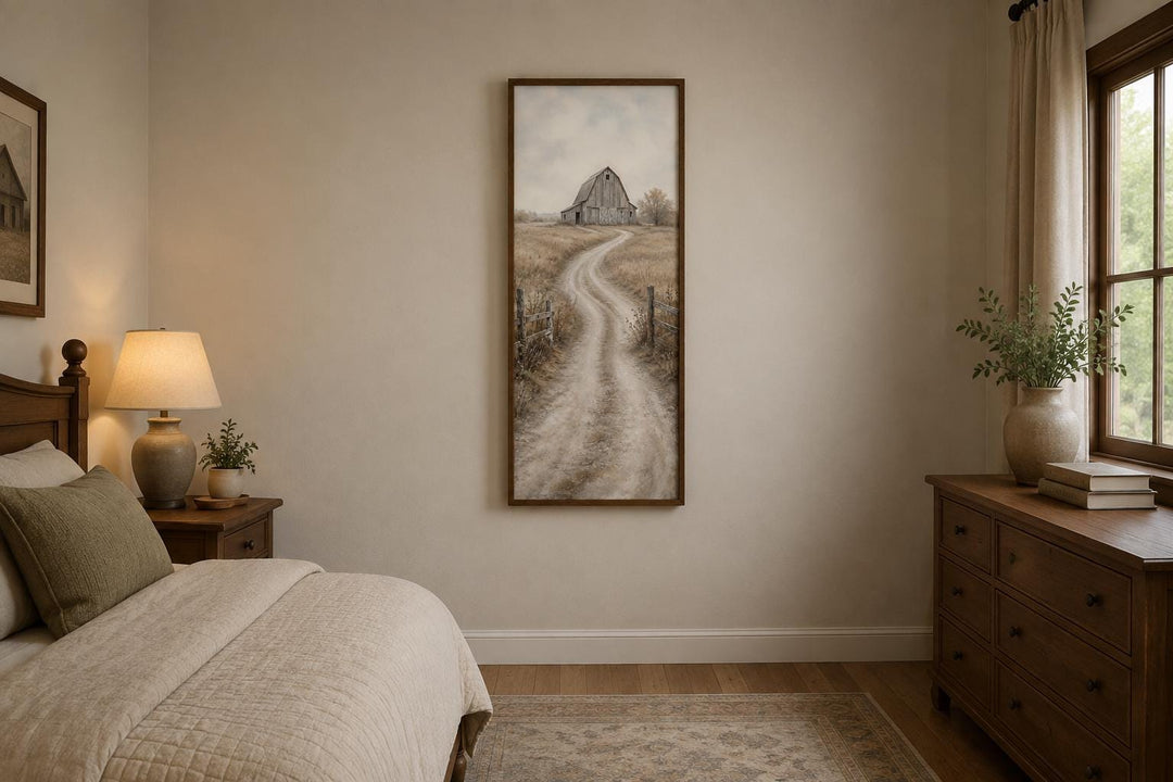 Tall narrow farmhouse wall art of a weathered barn and winding road in a neutral bedroom.