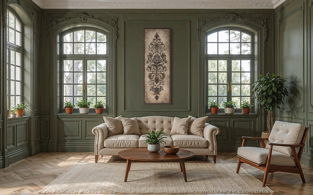A tall, narrow canvas featuring a neutral antique French damask design hangs in a green living room.