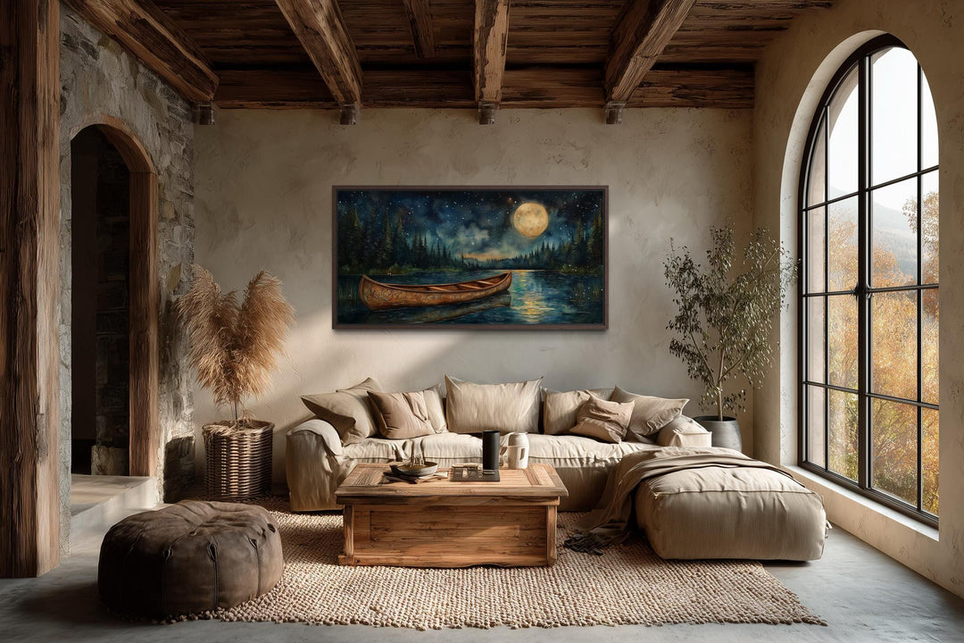 Canoe on moonlit lake and forest night scene canvas wall art hanging in a rustic cabin living room.