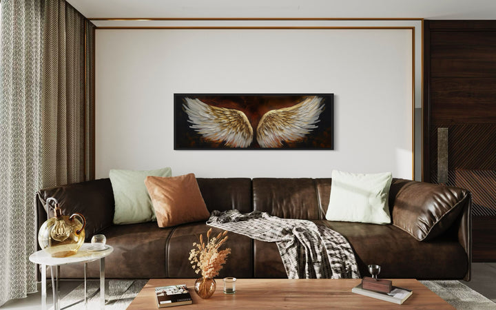 White Gold Angel Wings On Brown Background Horizontal Framed Canvas Wall Art in a living room with a brown couch