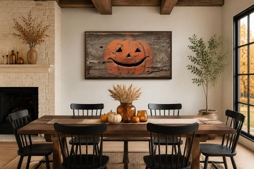 Primitive pumpkin on weathered wood canvas wall art in a rustic dining room with fall decor.