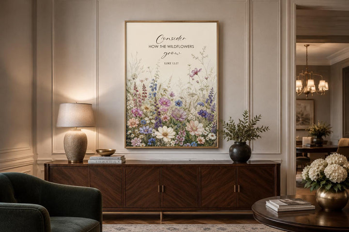 Wildflower watercolor wall art with Luke 12:27 scripture verse in a gold frame above a sideboard.