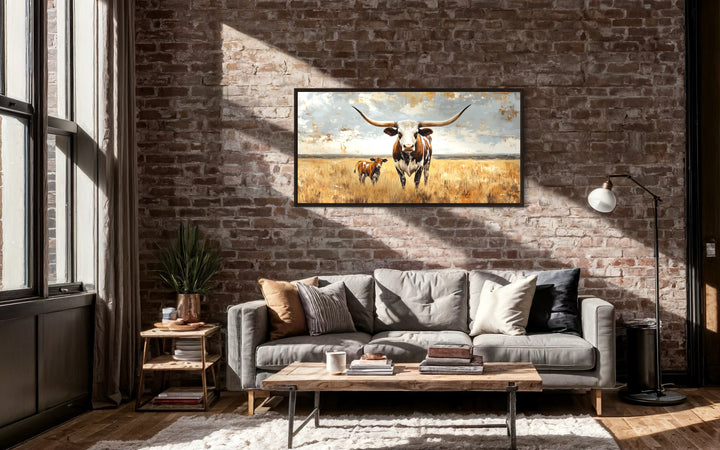 Texas Longhorn Cow With Calf In The Field Framed Canvas Wall Art on brick wall in living room