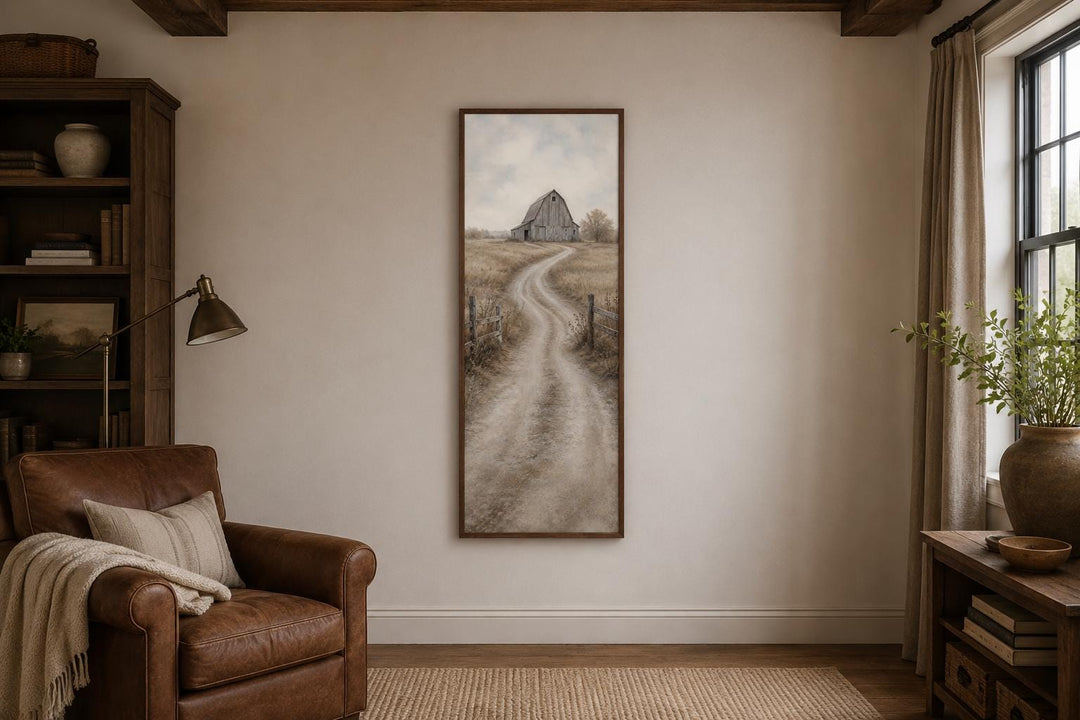 Tall narrow farmhouse wall art of a weathered barn and winding dirt road through golden fields.