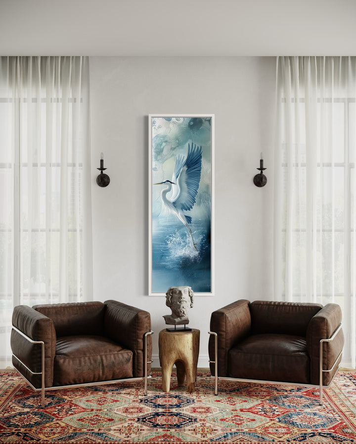 Tall Narrow Blue Heron In Flight Framed Vertical Canvas Wall Decor in a living room with two chairs