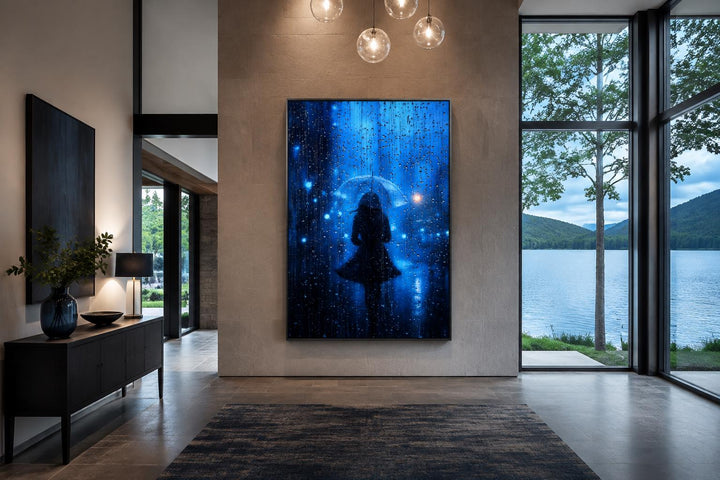 Vertical canvas wall art of a woman's silhouette with an umbrella in blue rain on a stone wall.