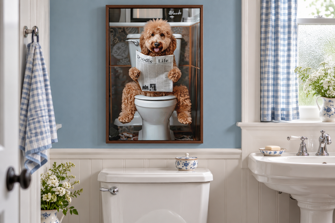 Framed canvas wall art of a Goldendoodle reading a newspaper on a toilet in a blue bathroom.