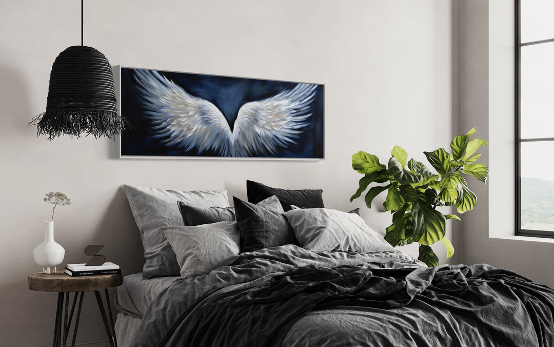 White Angel Wings On Blue Background Horizontal Framed Canvas Wall Art above dark bed