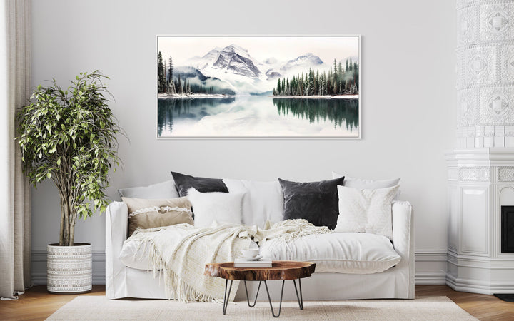 Muted Mountain Lake And Pine Tree Forest Landscape Framed Canvas Wall Art above white couch