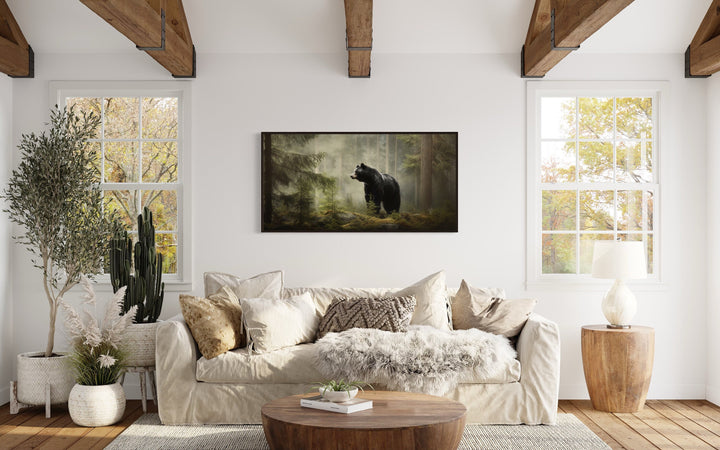 Black Bear In Fir Tree Forest Wall Art above beige couch