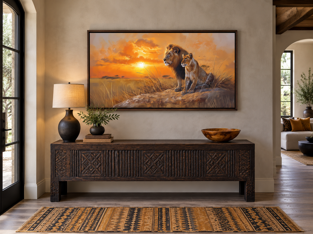 Framed canvas print of a lion and lioness at sunset above a rustic wooden console in an entryway.