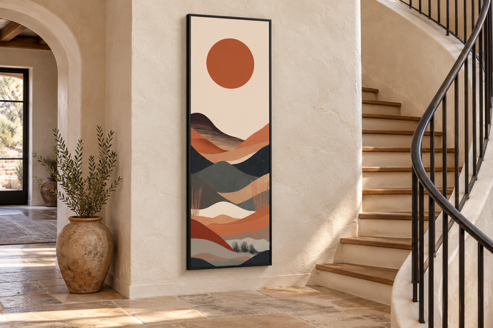 Long narrow vertical framed canvas wall art with a minimalist boho desert landscape and orange sun.