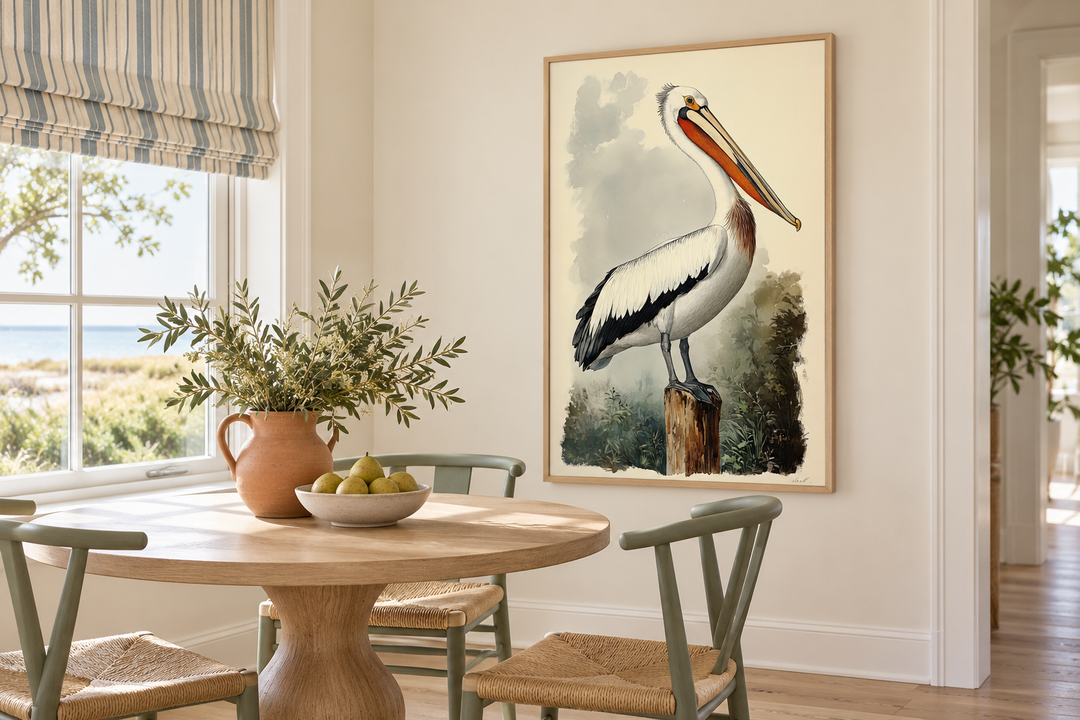 Vintage pelican illustration in a light wood frame hanging in a coastal dining room.