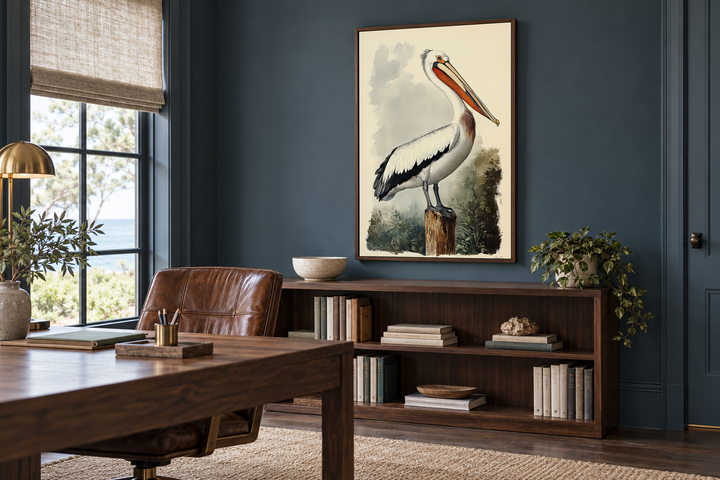 Vintage Pelican Framed Canvas Wall Art in a vertical walnut frame above a wooden bookshelf.