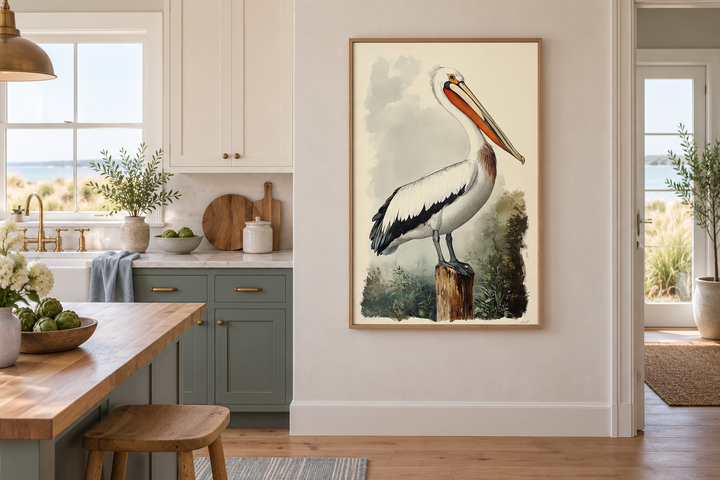 Vintage pelican illustration in a light oak frame, hanging on a neutral wall in a coastal kitchen.