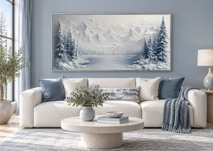 Snowy mountain lake with pine trees winter framed canvas wall art above a white sofa.