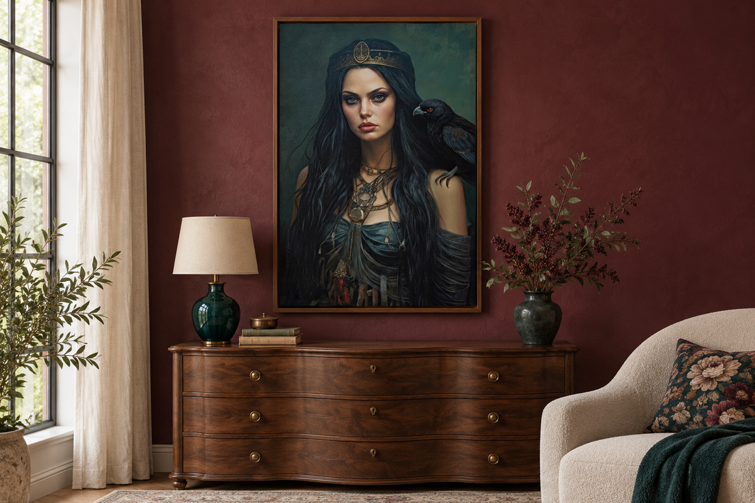 Framed canvas of The Morrigan goddess with a raven, hanging above a dark wood dresser in a red room.