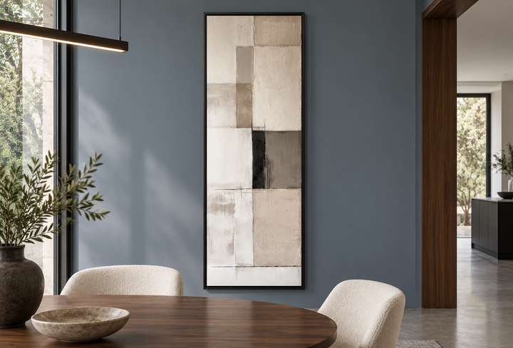 Vertical abstract geometric wall art with beige, black, and white panels in a black frame.