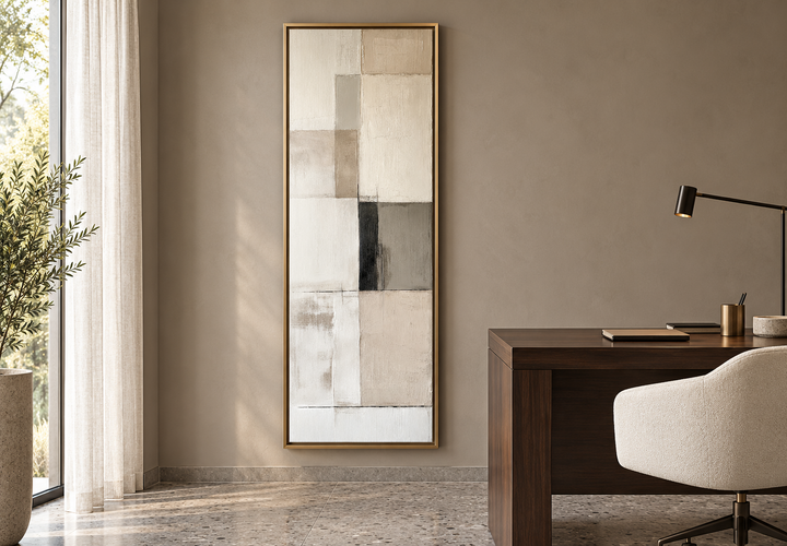 Vertical abstract geometric wall art in beige, black, and white with a gold frame in a home office.