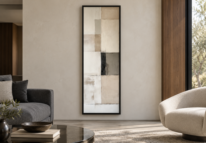 Vertical abstract geometric wall art with beige, black, and white panels in a black frame.