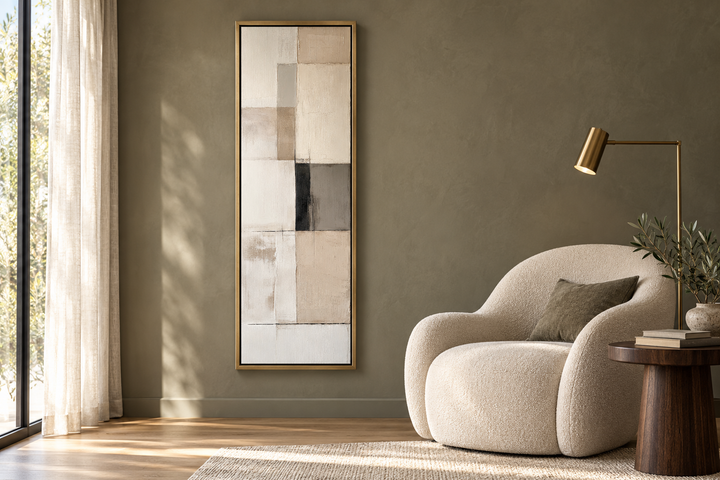 Vertical abstract geometric wall art with beige, black, and white panels in a gold frame.