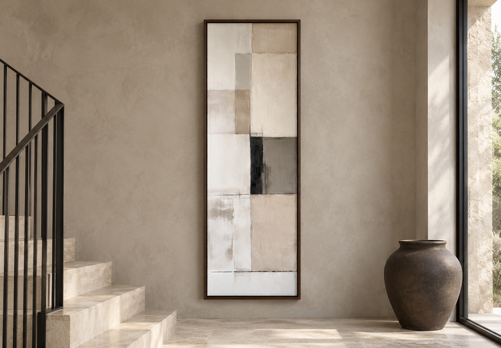 Vertical abstract geometric wall art in beige, black, and white on a neutral textured wall.