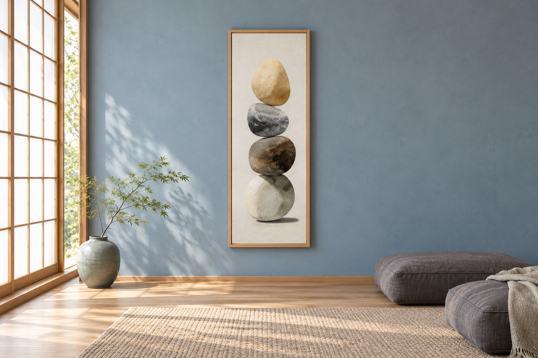 Vertical canvas wall art of four stacked stones in a minimalist room with blue walls.