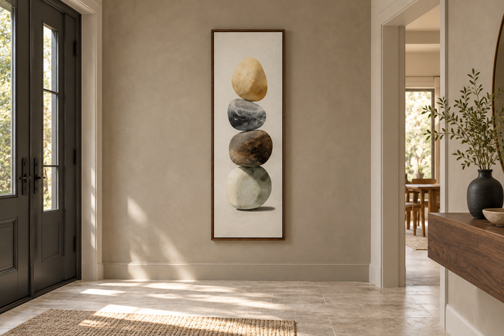 Vertical Zen Stacked Stones Canvas Wall Art in a wood frame on a neutral entryway wall.